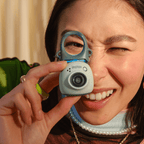 Sfeerafbeelding instax Pal™ camera Pistachio Green. De camera wordt vastgehouden en voor het gezicht van een dame gehouden.